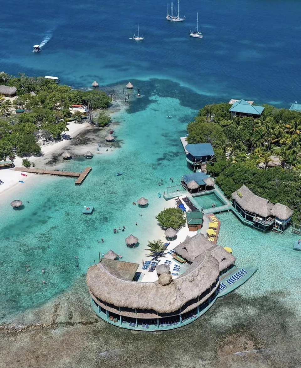 Aerial view of an overwater resort and bungalows in turquoise Caribbean water