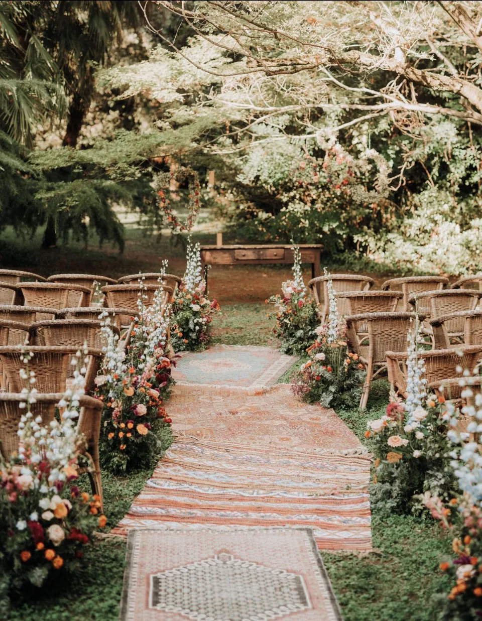 Garden wedding ceremony aisle lined with rustic benches and flowers