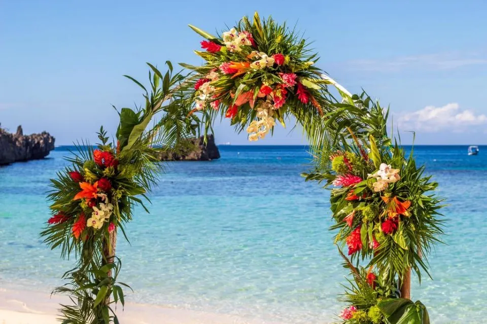 Tropical flower wedding arch on the beach overlooking the Caribbean Sea