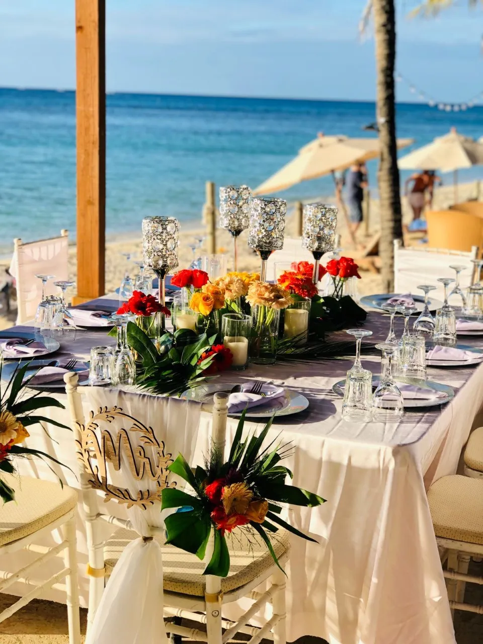 Beach wedding reception table decorated with tropical flowers