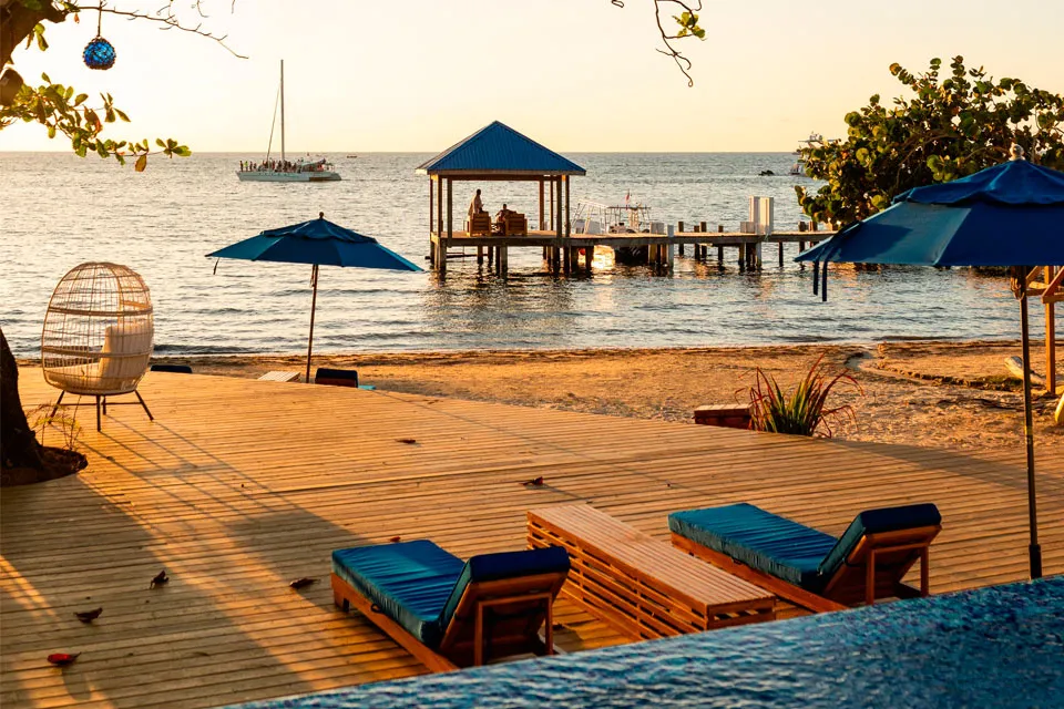Pool deck with loungers and a gazebo pier at Blue Roatan