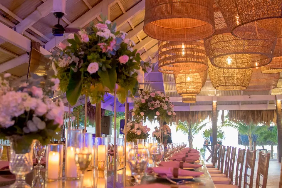 Wedding reception dinner under woven lamps and flowers at San Simon Beach Club, West Bay