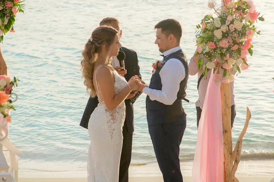 Couple exchanging rings at a beach wedding ceremony
