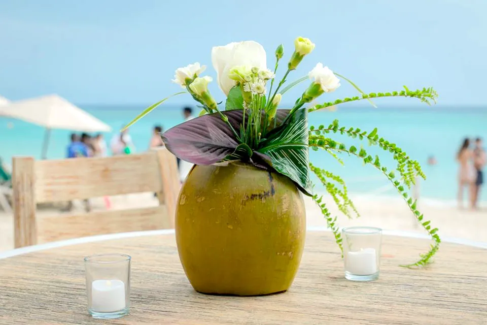 Coconut centerpiece with white flowers on a beach wedding table