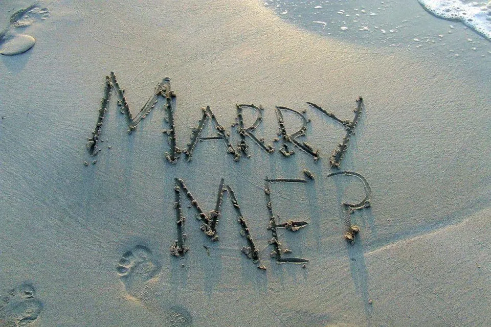Marry me written in the sand on a Roatán beach