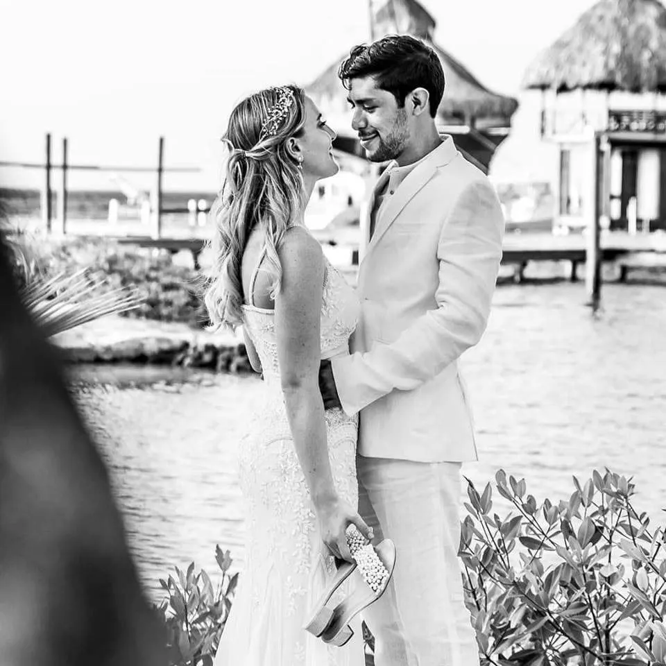 Black and white photo of a bride and groom by the water in Roatán