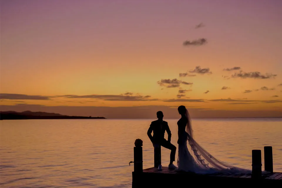 Silhouette of a couple on a dock at sunset for a small wedding in Roatán