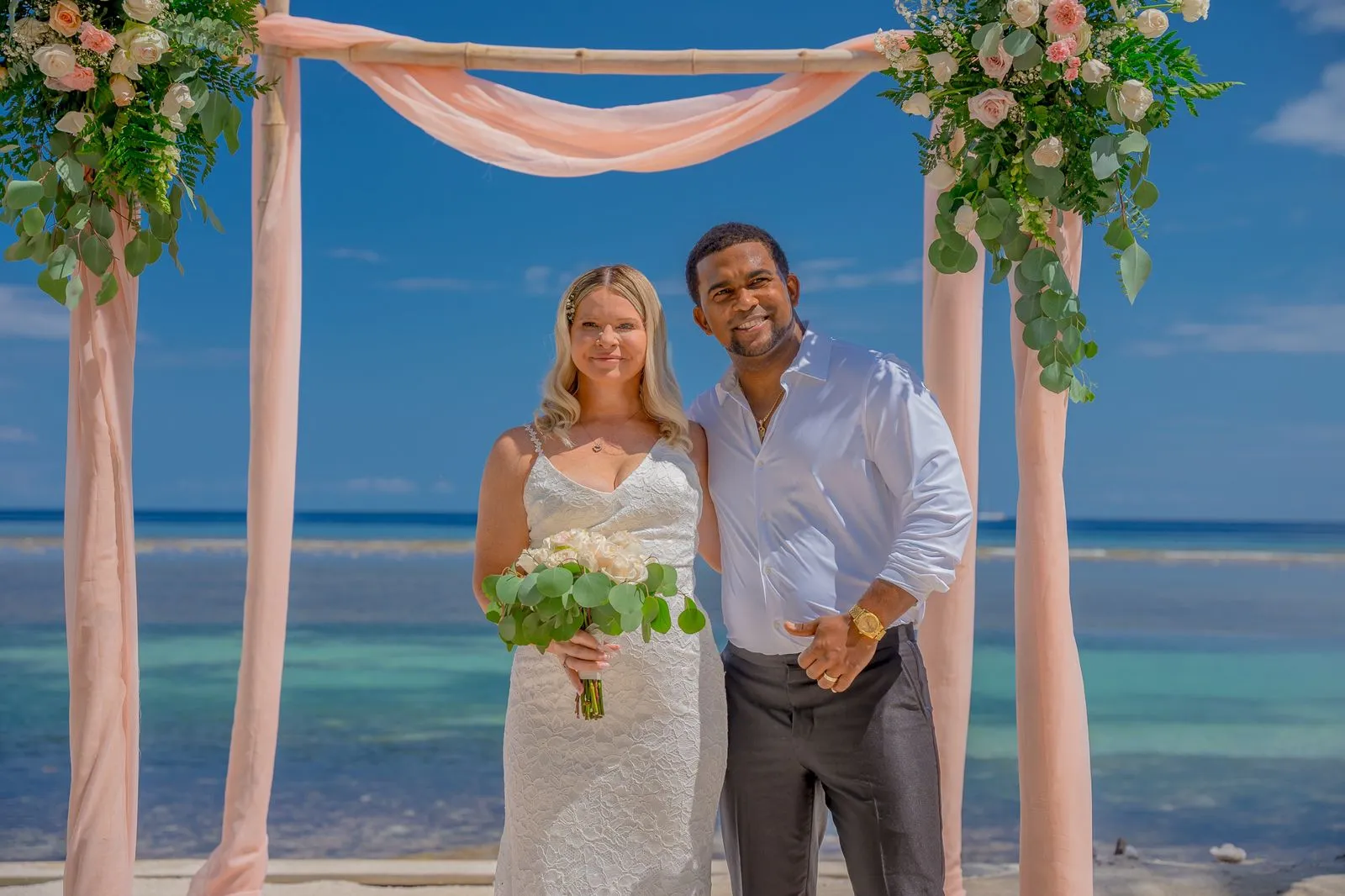 Why Cruise Weddings are Beneficial in Roatan 3 Cruise wedding couple under a pink draped arch on the beach in Roatán