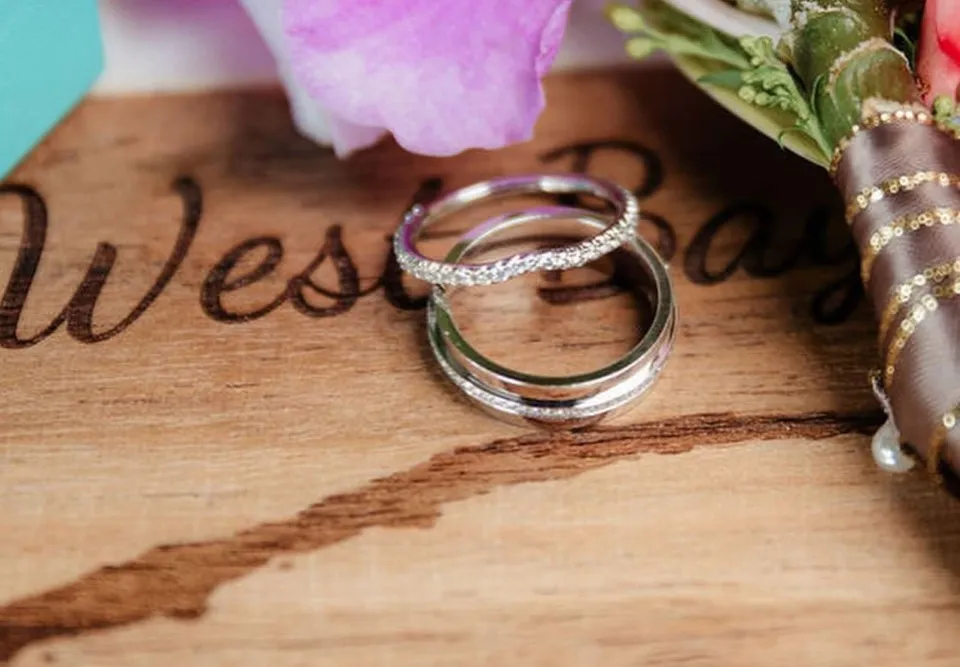 Wedding rings on an engraved West Bay wooden souvenir