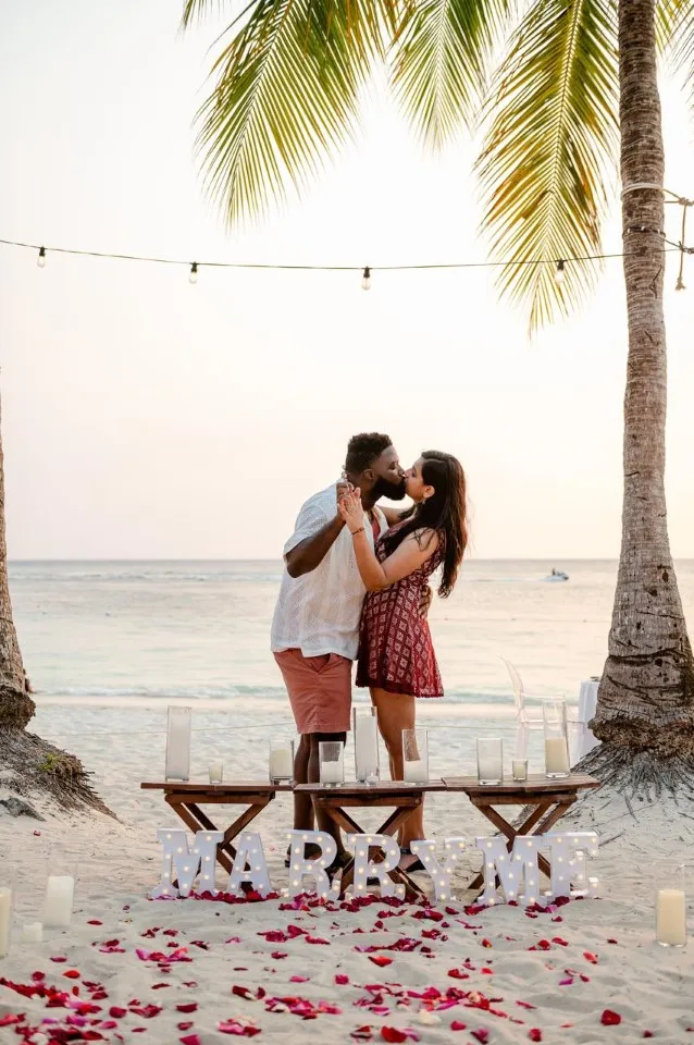 Couple kissing after a sunset proposal on West Bay Beach, Roatán