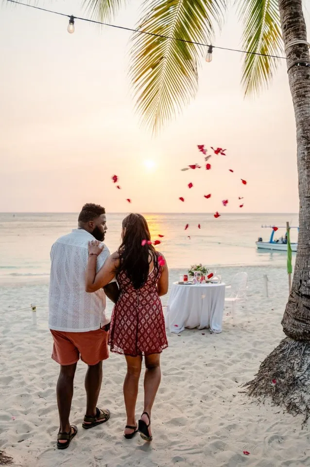 Rose petals thrown over a newly engaged couple on West Bay Beach