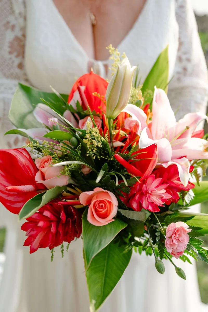 Bride holding a bouquet of tropical flowers, lilies and roses