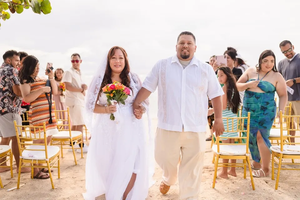 Fabian and Elisa walking up the aisle after their cruise wedding at Curación