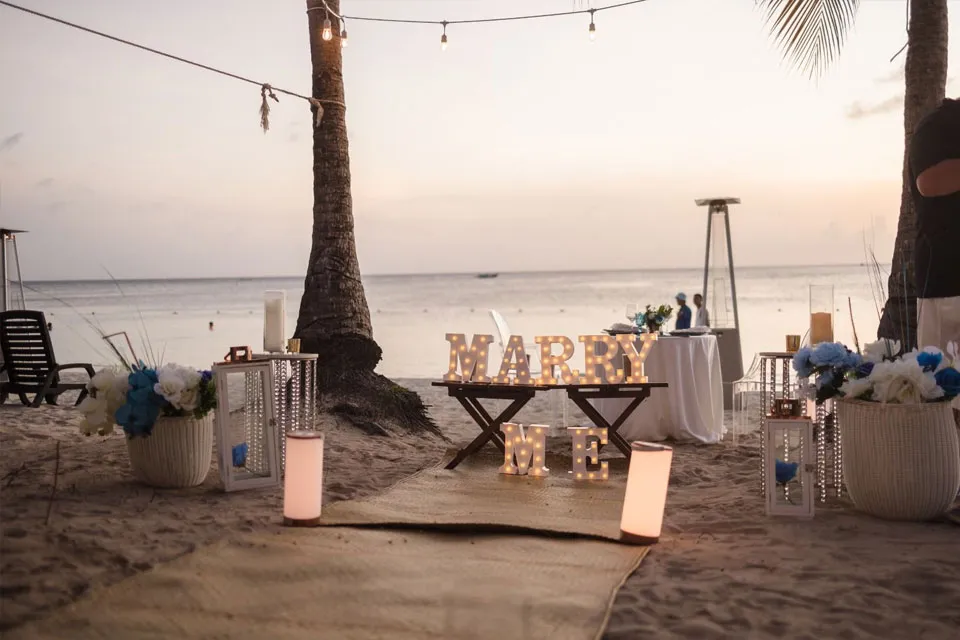 Sunset proposal setup with MARRY ME lights on West Bay Beach, Roatán