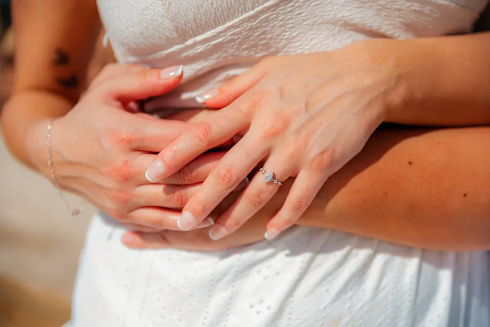 Close-up of hands showing an engagement ring after a surprise proposal at Curación