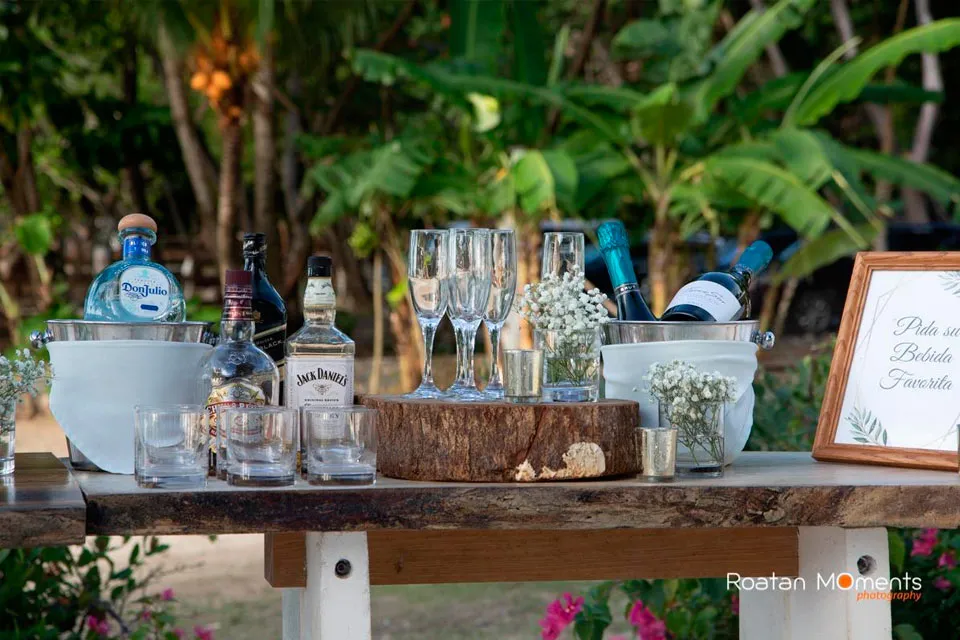 Wedding bar table with drinks and glasses in the gardens of Luna Beach Resort