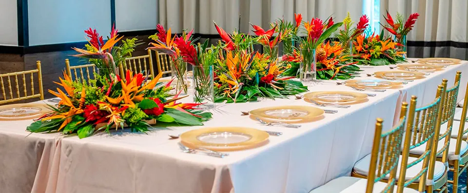 Reception table with tropical flower runner at Jen and Xerxes' wedding at Kimpton Grand Roatán