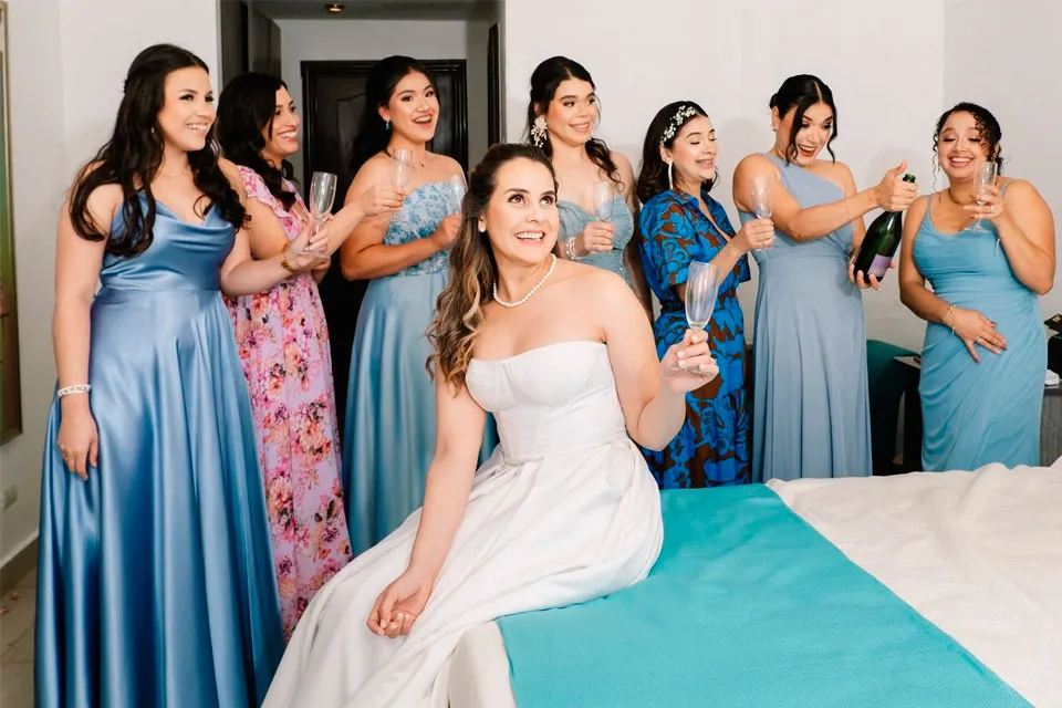 Bride and bridesmaids toasting with champagne while getting ready