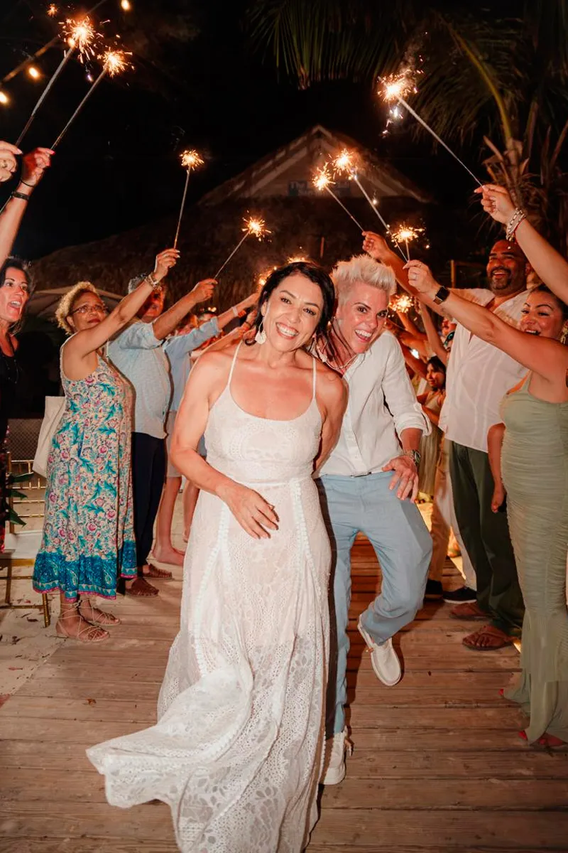 Bride walking through a sparkler send-off at night in Roatán