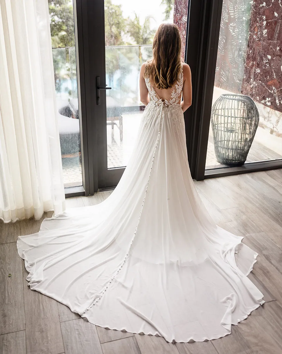 Bride in her wedding gown by a window before her cruise wedding