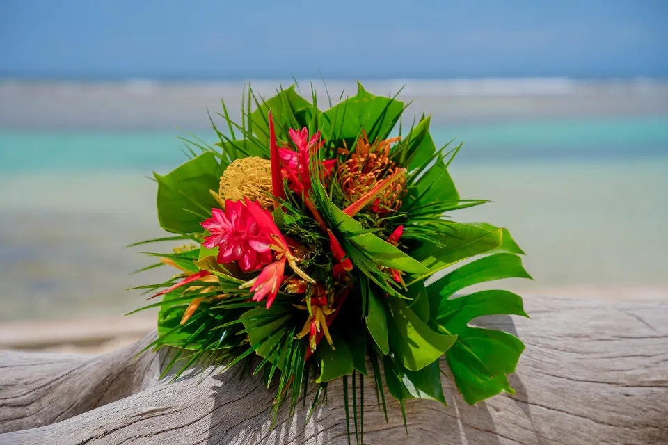 Tropical bouquet on driftwood by the sea at Tambra and Bob's wedding at Curación