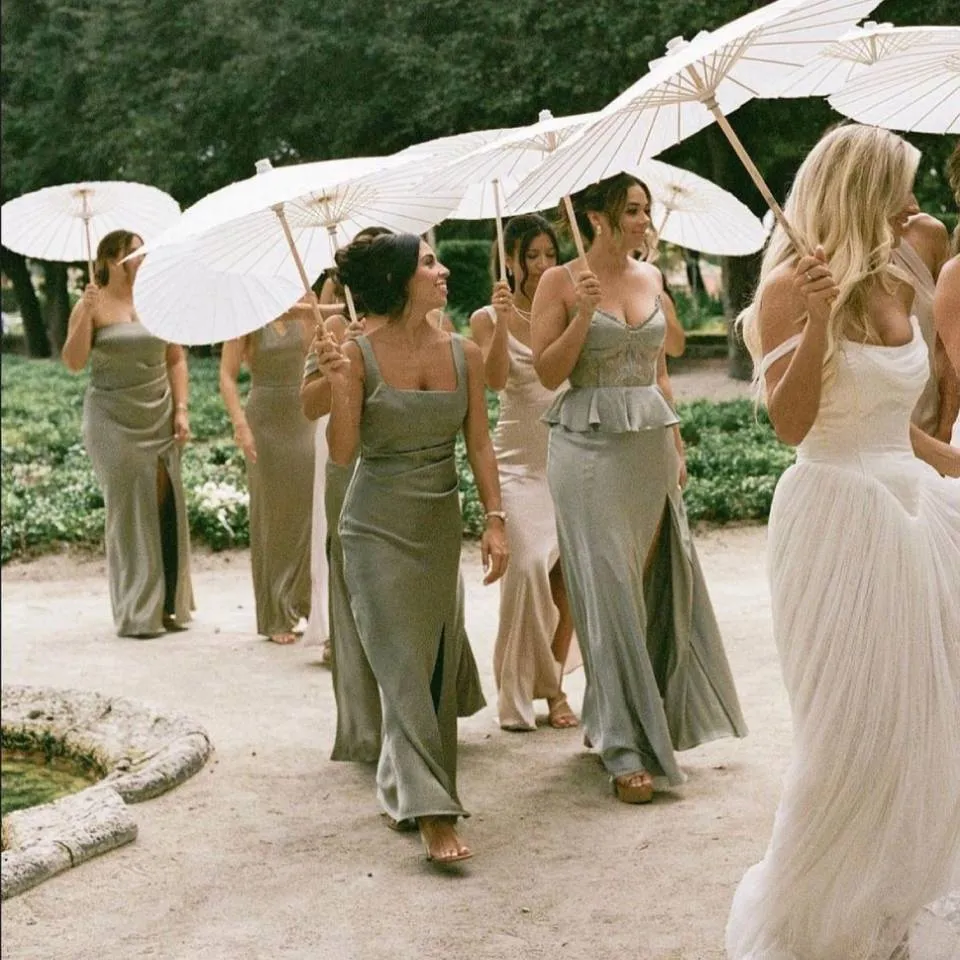 Bridesmaids carrying white parasols at a destination wedding