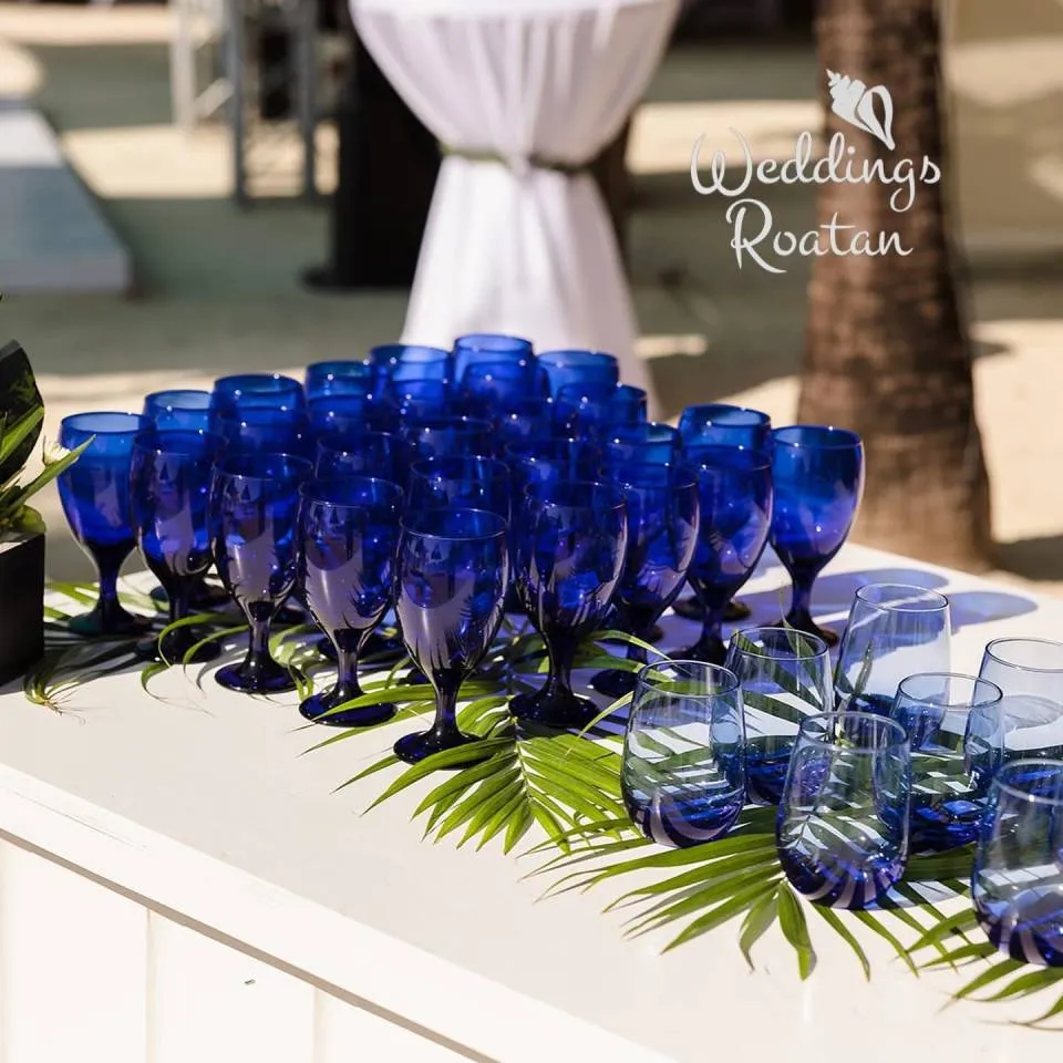Blue glassware on a welcome table decorated with palm leaves