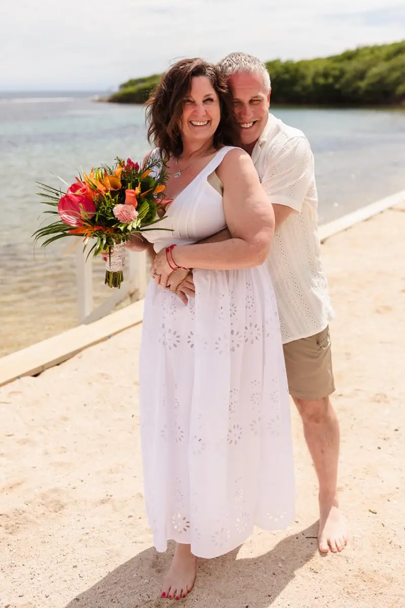 Brian and Heather embracing on the beach after their cruise elopement at Curación