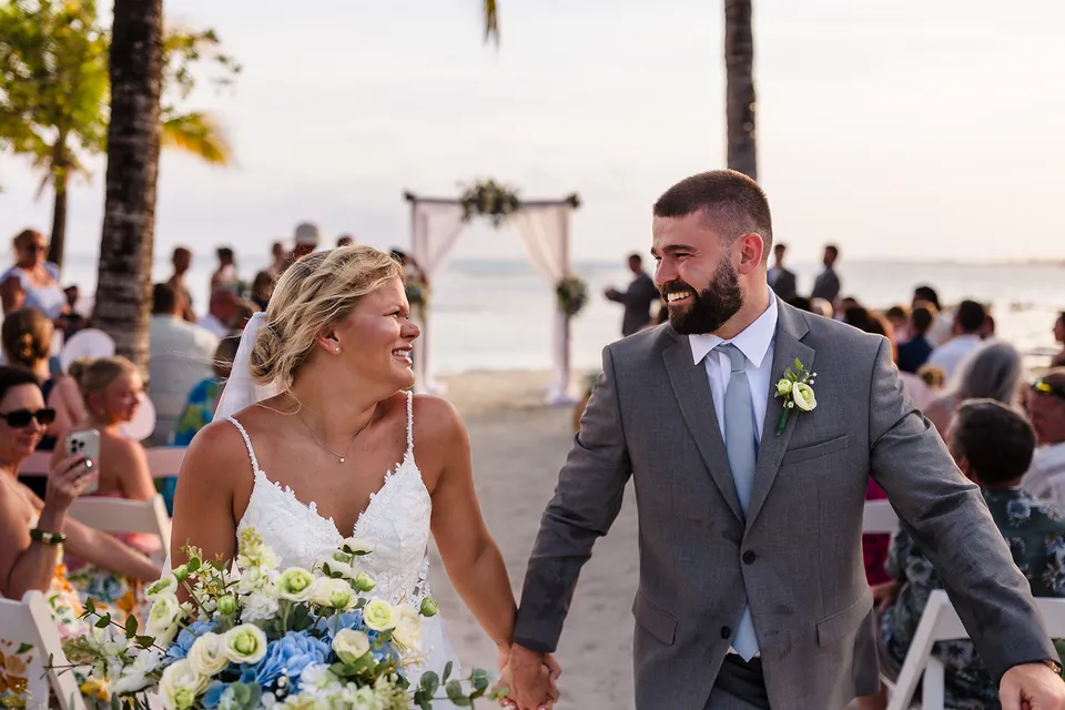 Chloe and Avery walking back up the aisle after their beach wedding ceremony at Bando Beach, Utila