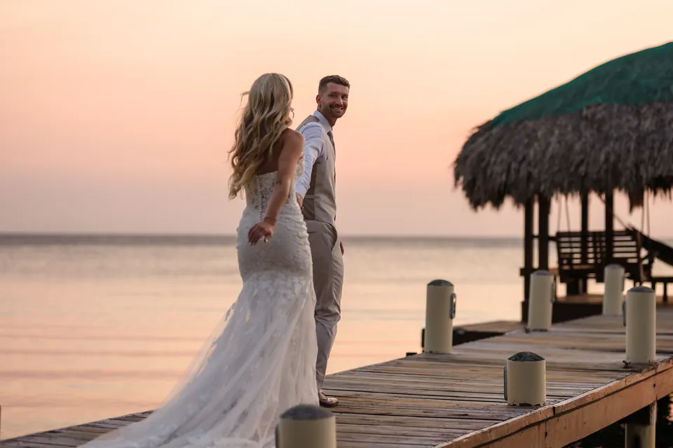 Turtle Beach Roatan couple on the wooden dock at sunset Bride and groom on the wooden dock at sunset at Turtle Beach, Roatán